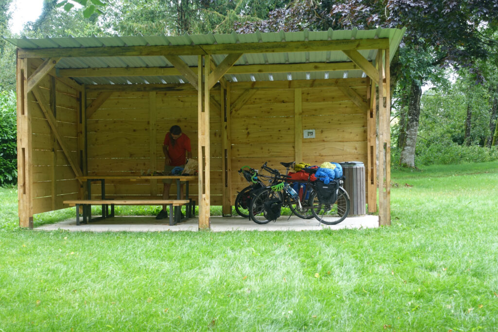 Picknicktisch in offenem Unterstand wo sogar noch Platz bleibt für die Velos.