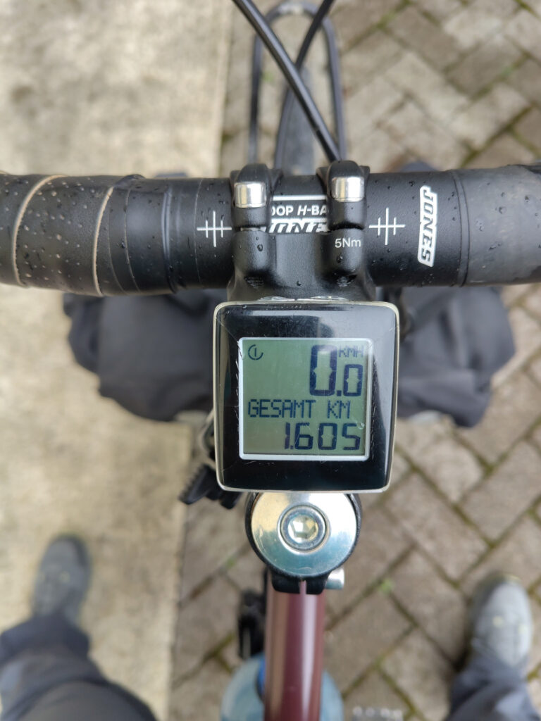 Blick von oben auf den Fahrradlenker. Auf dem Fahrradcomputer auf dem Lenkervorbau wird die Anzahl der gefahrenen Kilometer mit 1605 angezeigt.