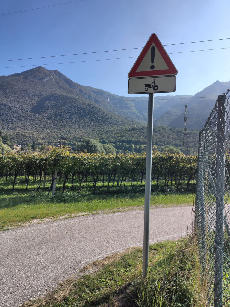 Warnschild für Traktoren am Rande des Radwegs. Das Traktorsymbol sieht einem Lastenfahrrad sehr ähnlich.